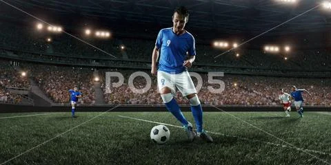 Soccer player performs an action play on a professional stadium Stock Photos
