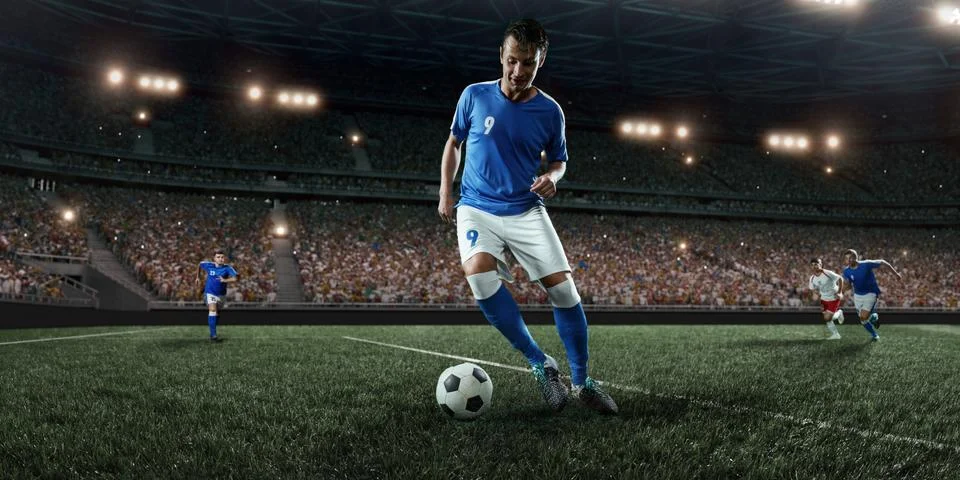 Soccer player performs an action play on a professional stadium Stock Photos