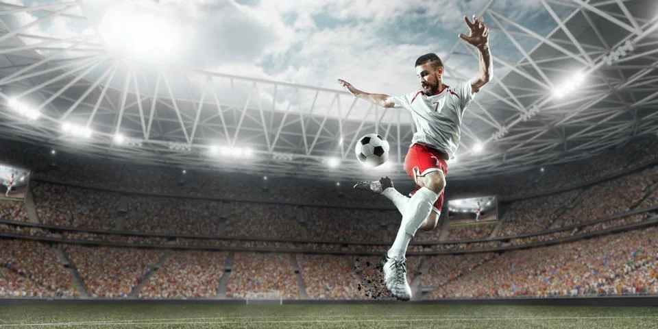 Soccer player performs an action play on a professional stadium Stock Photos
