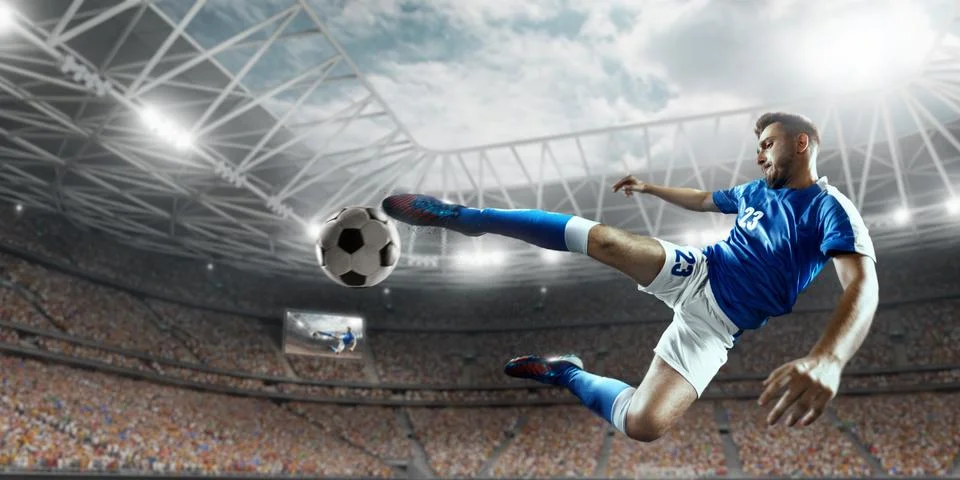 Soccer player performs an action play on a professional stadium Stock Photos