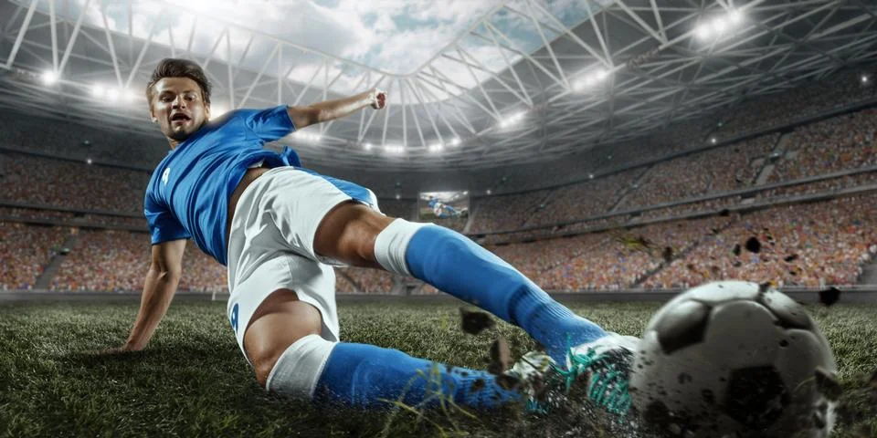 Soccer player performs an action play on a professional stadium Stock Photos