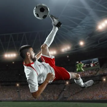 Soccer player performs an action play on a professional stadium Stock Photos