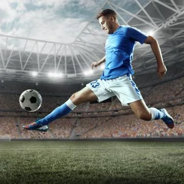 Soccer player performs an action play on a professional stadium Stock Photos