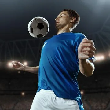 Soccer player performs an action play on a professional stadium Stock Photos