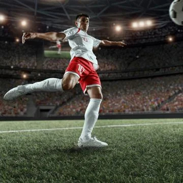 Soccer player performs an action play on a professional stadium Stock Photos
