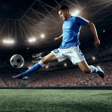 Soccer player performs an action play on a professional stadium Stock Photos