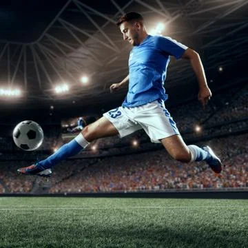 Soccer player performs an action play on a professional stadium Stock Photos