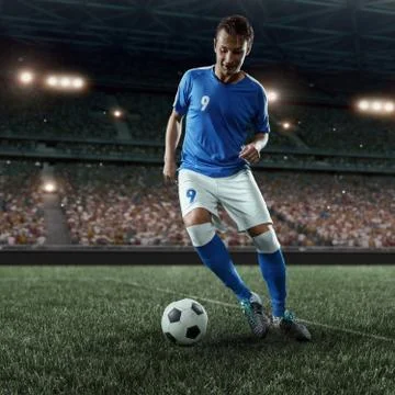 Soccer player performs an action play on a professional stadium Stock Photos