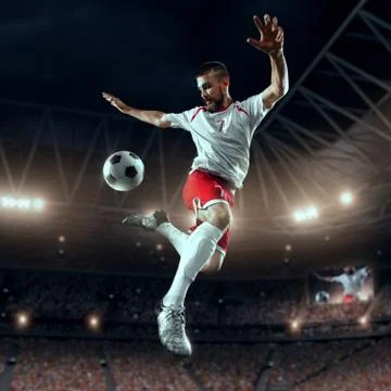 Soccer player performs an action play on a professional stadium Stock Photos