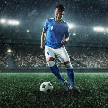 Soccer player performs an action play on a professional stadium Stock Photos