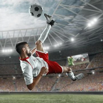Soccer player performs an action play on a professional stadium Stock Photos