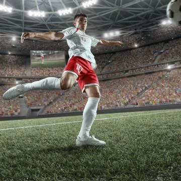 Soccer player performs an action play on a professional stadium Stock Photos