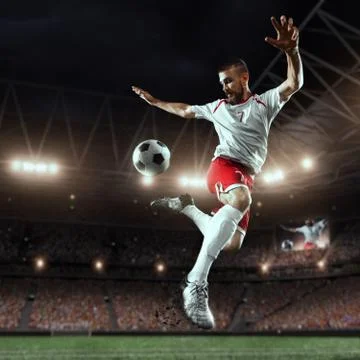 Soccer player performs an action play on a professional stadium Stock Photos