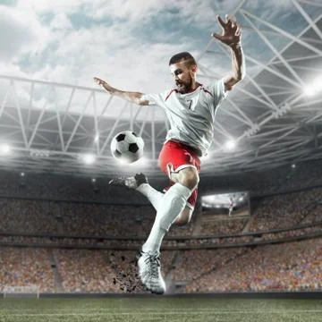 Soccer player performs an action play on a professional stadium Stock Photos