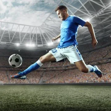 Soccer player performs an action play on a professional stadium Stock Photos