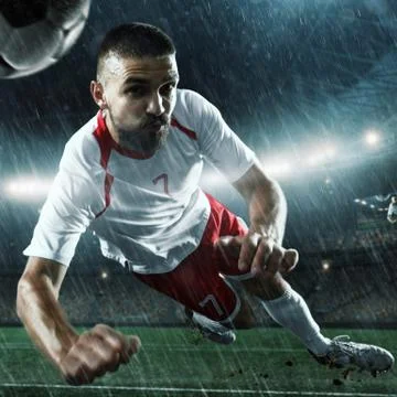 Soccer player performs an action play on a professional stadium Stock Photos