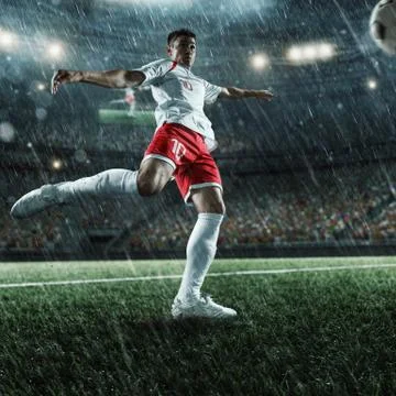 Soccer player performs an action play on a professional stadium Stock Photos