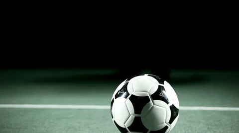 Soccer player picks up a ball and holds it out. Medium shot. Video stock 33836747