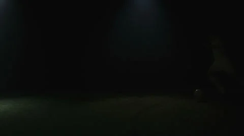 A soccer player running through the shadows while kicking the ball Stock Footage 34008048