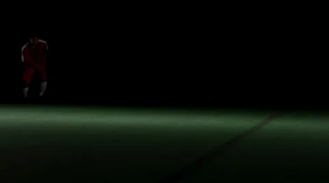 A soccer player runs into frame and then kicks the ball off the screen Stock Footage 33867650
