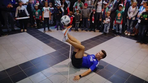 Soccer player shows tricks with ball to people in stadium Stock Footage 129075809