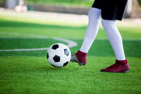 Soccer player speed run to control and shoot ball to goal on artificial turf Stock Photos