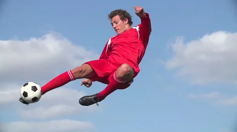 Soccer player volleys ball in mid air Stock Footage
