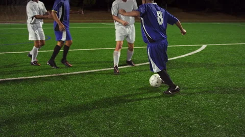 Soccer players pass the ball down the field at night and make a goal Stock Footage 56202513