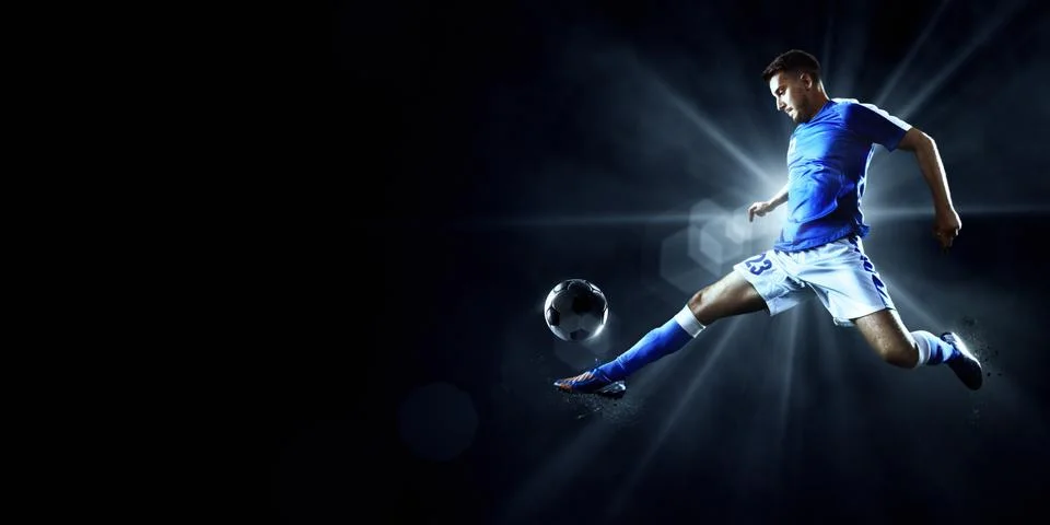 Soccer players performs an action play on a professional stadium Stock Photos