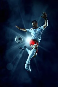 Soccer players performs an action play on a professional stadium Stock Photos