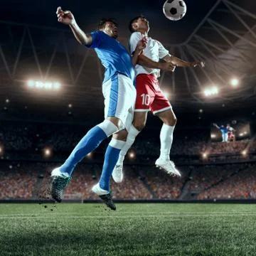 Soccer players performs an action play on a professional stadium Stock Photos