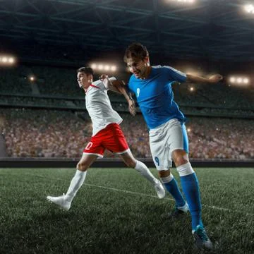 Soccer players performs an action play on a professional stadium Stock Photos