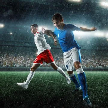 Soccer players performs an action play on a professional stadium Stock Photos