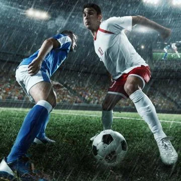 Soccer players performs an action play on a professional stadium Stock Photos