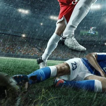 Soccer players performs an action play on a professional stadium Stock Photos