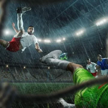 Soccer players performs an action play on a professional stadium. View throug Stock Photos