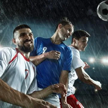 Soccer players performs an action play on a professional stadium Stock Photos