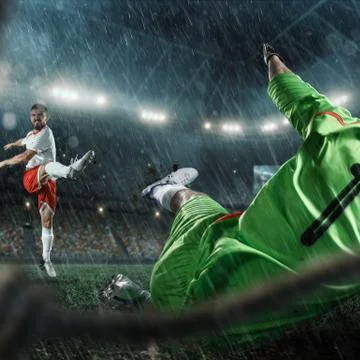 Soccer players performs an action play on a professional stadium. View throug Stock Photos