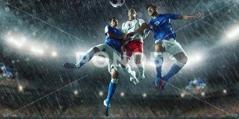 Soccer players performs an action play on a professional stadium Stock Photos