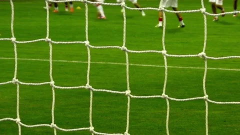Soccer players training on field viewed through goal net Stock Footage 336398659