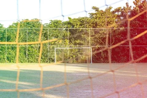Soccer posts in park, field is partially covered in the shadow. Trees in the  Stock Photos