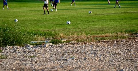 Soccer practice session with multiple balls on a green grass field Stock Photos