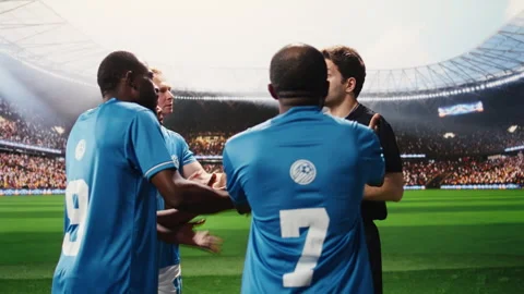 Soccer referee in black showing yellow card to protesting player on pitch Stock Footage 337994982