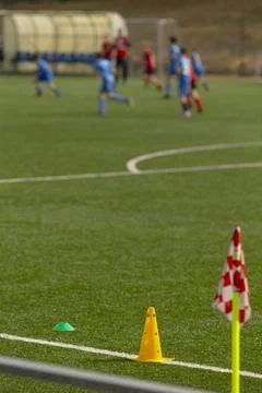 Soccer sideline with training cone and corner flag on green pitch Stock Photos