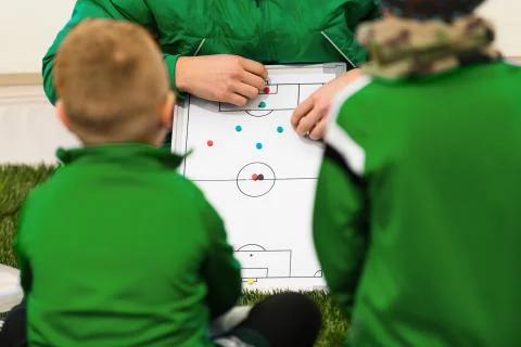 Soccer trainer coach explaining tactics to kids football team Stock Photos