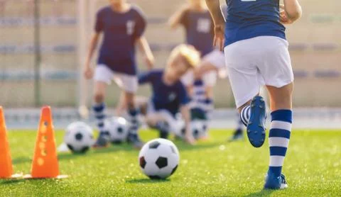 Soccer training practice. Player running with football ball in sports cleats Stock Photos