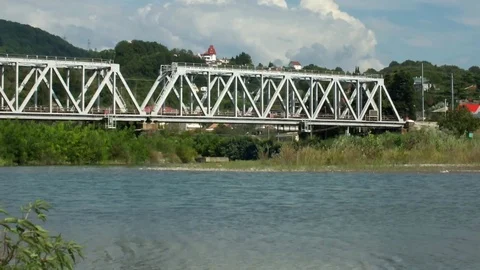 SOCHI, RUSSIA - 08/12/2016: Passenger train rides on the railway bridge Stock Footage 111163545