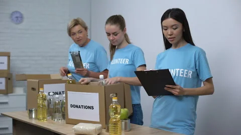 Social center workers preparing food donation boxes making notes, volunteering Stock Footage 113399892