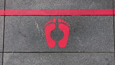 Social distancing, red painted floor line and two feet. Stock Footage 132797431