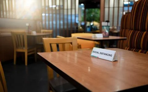 Social Distancing sign board stand on the table in restaurant. Corona Virus p Stock-Fotos